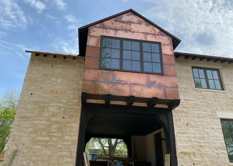 Copper metal panel facade on a stone building for Metal Roof Coating in Rose